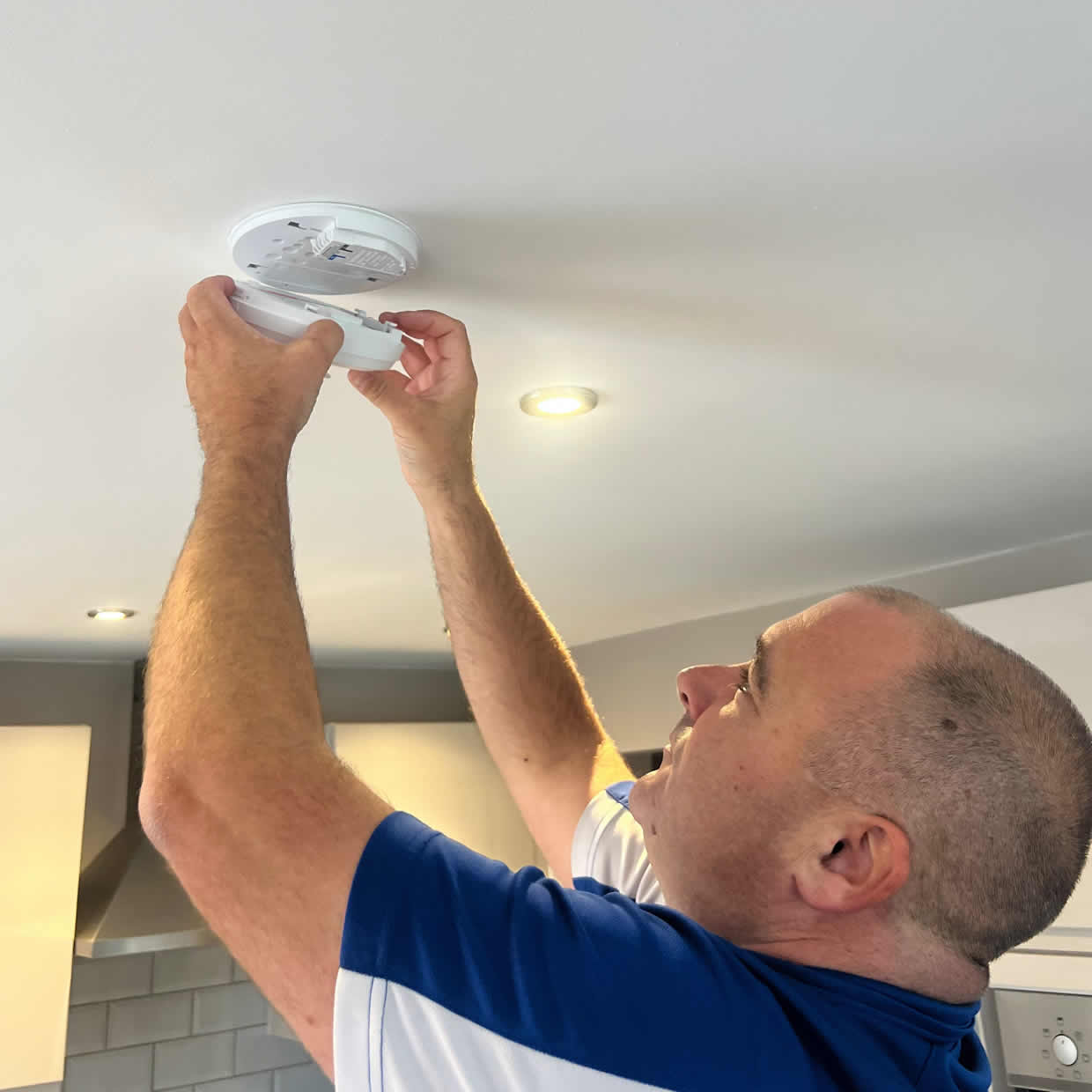 Smoke alarm being installed on a ceiling in Loughton